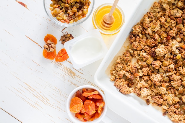 Granola preparação, fundo branco de madeira