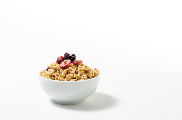 Foto granola en un recipiente sobre fondo blanco.