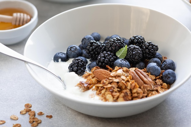 Granola con yogur, arándanos y moras sobre un fondo de hormigón