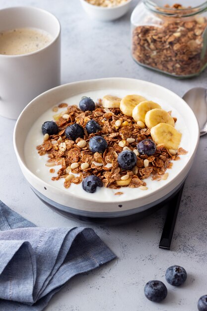 Granola con yogur, arándanos, nueces, plátano y miel. Muesli. Alimentación saludable. Comida vegetariana.