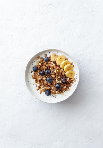 Foto granola con yogur, arándanos, nueces, plátano y miel. muesli. alimentación saludable. comida vegetariana.