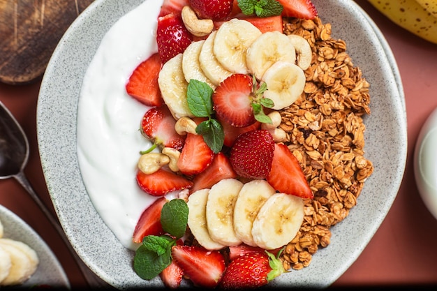 Granola con yogur fresa y plátano en un bol