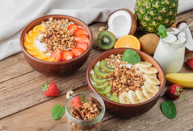 Granola con yogur griego y frutas sobre un fondo de madera en estilo rústico