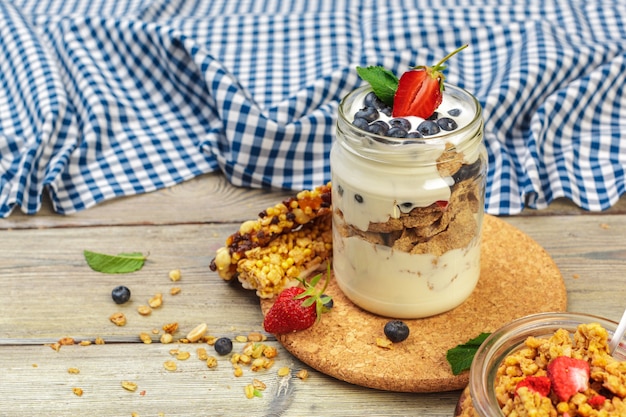 Granola, yogurt y fresas en frascos