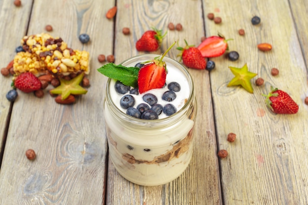 Granola, yogurt y fresas en frascos