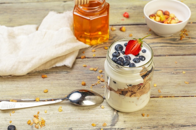 Granola, yogurt y fresas en frascos