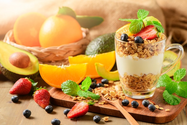 Granola y yogurt y frutas sobre cobertura en vaso.