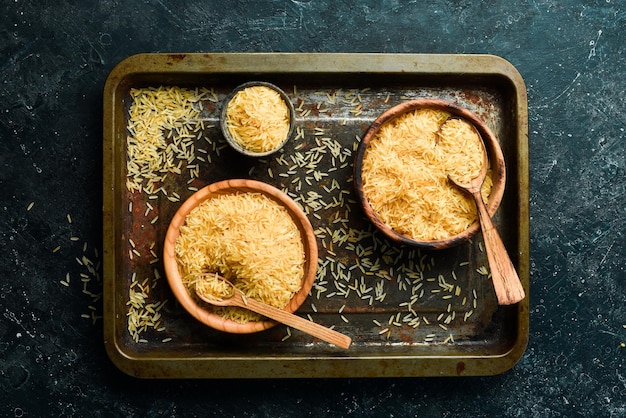 Grañones de arroz orgánico en un cuenco de madera sobre un fondo de piedra Alimentos saludables