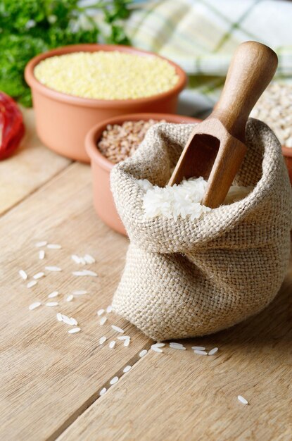 Granos de arroz orgánico en saco de arpillera en la mesa de la cocina