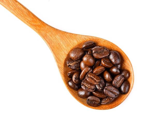 Granos de café aislados en una cuchara de madera sobre fondo blanco.