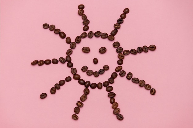 Granos de café aislados en la opinión superior del fondo blanco con la cara o el sol de la sonrisa