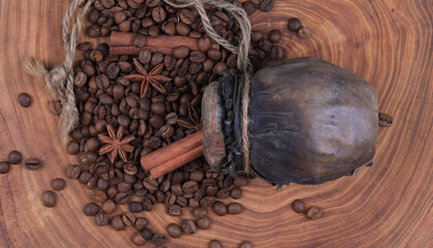 Granos de café en una antigua botella de madera sobre una mesa de madera