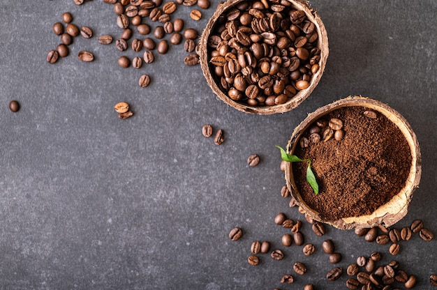 Granos de café arábica negros aromáticos recién molidos en un tazón de coco, vista superior con lugar para texto