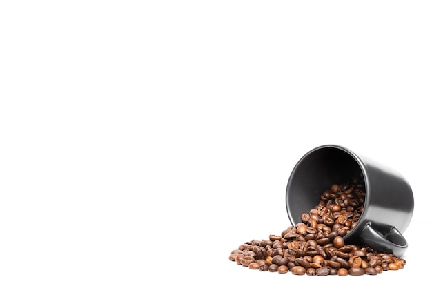 Foto granos de café arábica en una taza negra sobre fondo blanco con copyspace