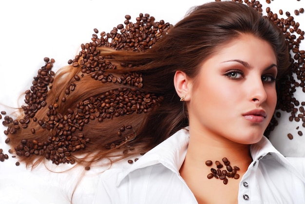 Foto granos de café en el cabello de una hermosa joven