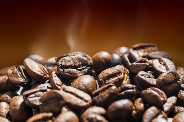 Granos de café calientes sobre fondo marrón. Imagen macro con poca profundidad de campo.