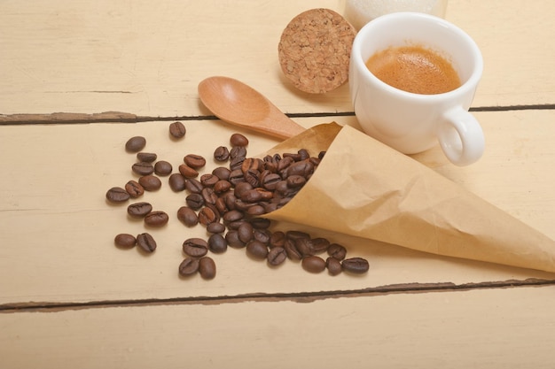 Granos de café y cuchara en la mesa