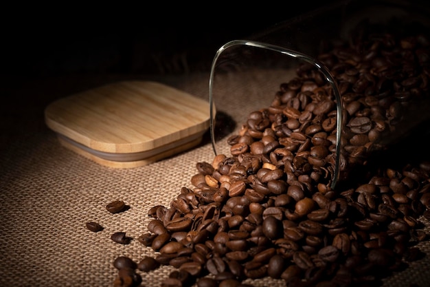 Foto los granos de café se derramaron del frasco sobre la mesa de la cocina