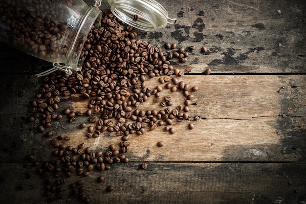 Granos de café en el fondo de madera del grunge.