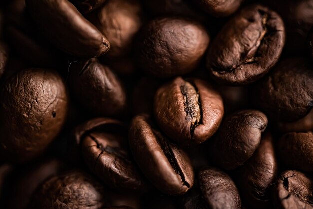 Granos de café en grano tostado de fondo con un rico sabor, la mejor bebida matutina y una combinación de lujo