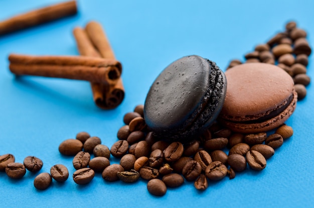 Foto granos de café y macarrones de chocolate en azul con un lugar debajo del texto