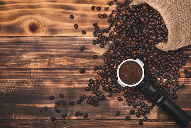 Granos de café marrón frescos en la mesa de madera.