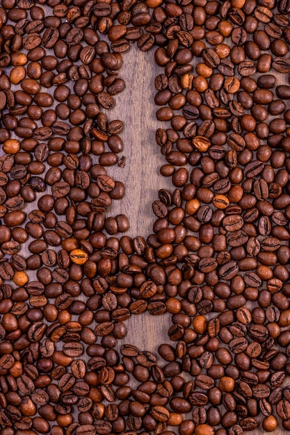 Granos de café naturales en el suelo de madera formando el signo de exclamación Concepto del Día Internacional del Café 1 de octubre