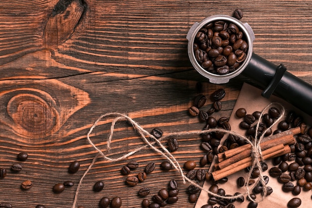 Granos de café y palitos de canela en la mesa de madera rústica, vista desde arriba con espacio para texto. Naturaleza muerta. Bosquejo. Endecha plana