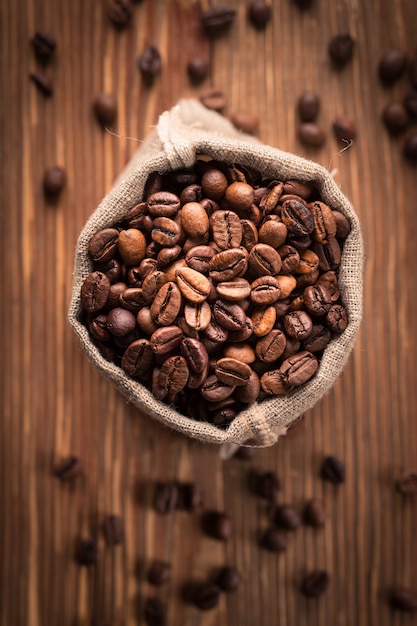 Granos de café recién tostados en saco de arpillera