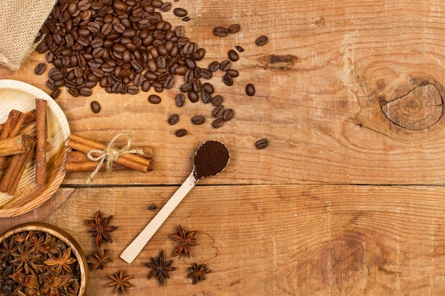 Granos de café en un saco de arpillera sobre una mesa de madera en una vista superior