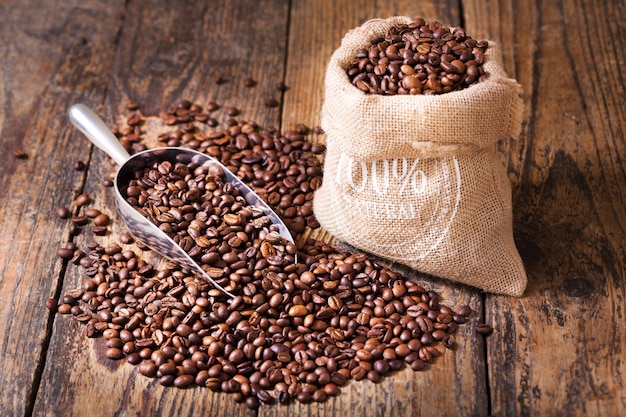 Granos de café en un saco de mesa de madera