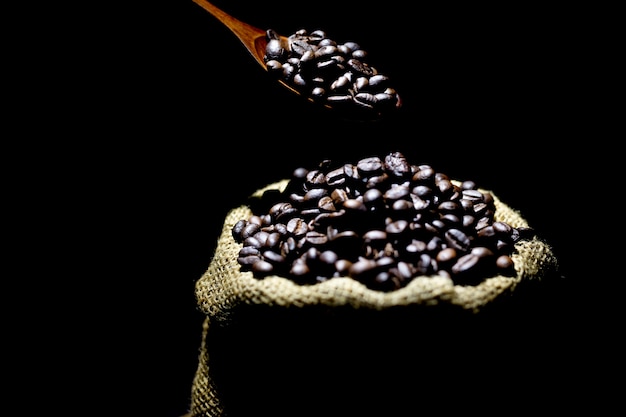 Granos de café en un saco sobre un fondo de color oscuro