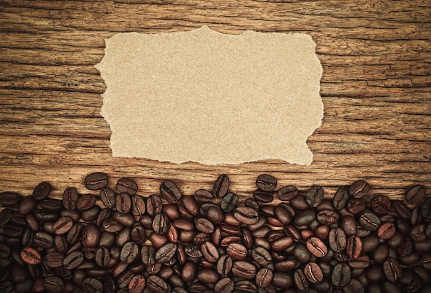 granos de café sobre fondo de madera Papel marrón rasgado blanco para insertar texto
