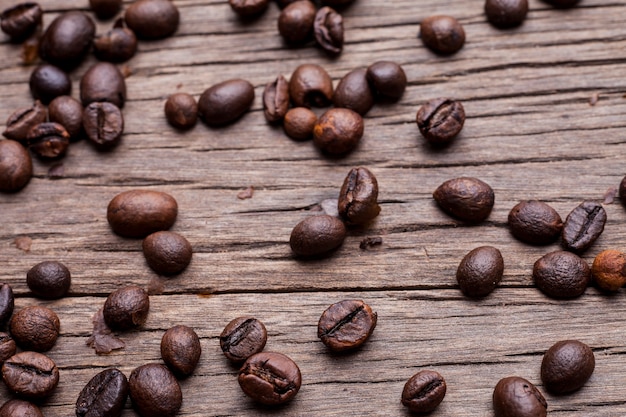 Granos de café sobre fondo de piso de madera vieja.