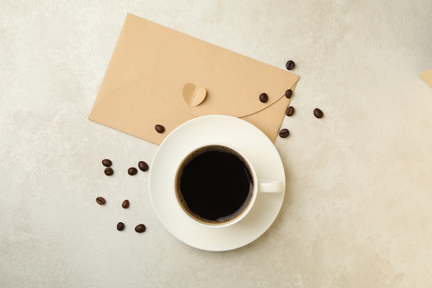 Granos de café, taza de café y sobre sobre fondo de textura