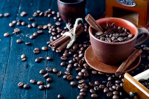 Granos de café en taza con canela y anís estrellado