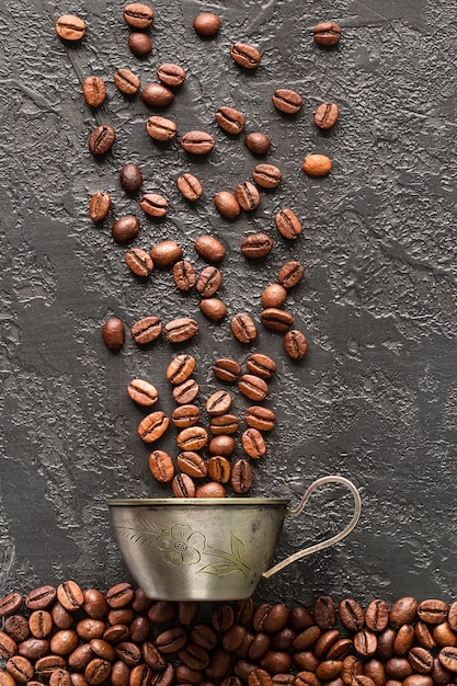 Granos de café y taza sobre fondo de hormigón gris