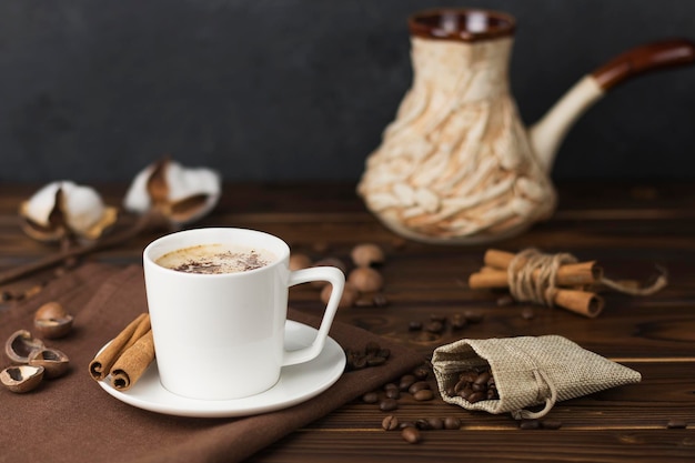 granos de café en una taza sobre una mesa de madera