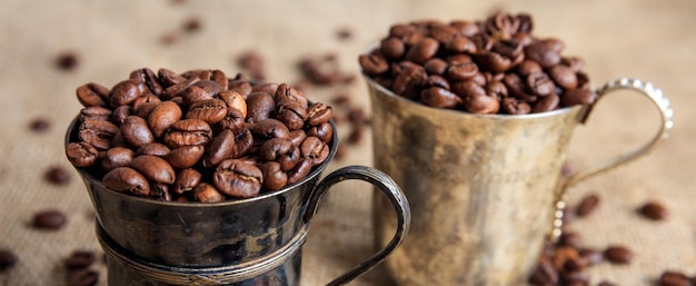 Granos de café en tazas viejas en una arpillera