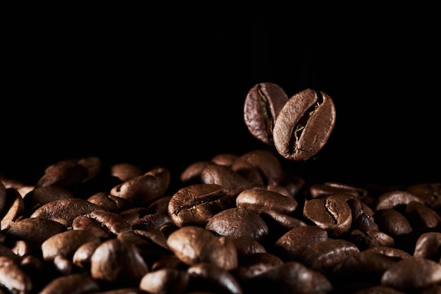 Granos de café tostados aislados de cerca en el camino de recorte de fondo negro