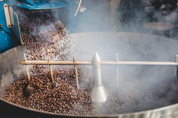 Granos de café tostados al vapor en el cilindro de refrigeración