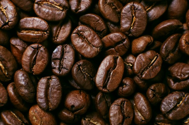 Granos de café tostados aromáticos, fondo marrón