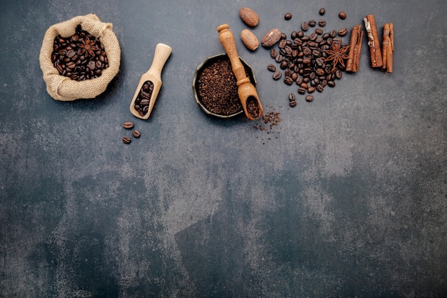 Granos de café tostados con café en polvo e ingredientes sabrosos para preparar un café sabroso en piedra oscura.