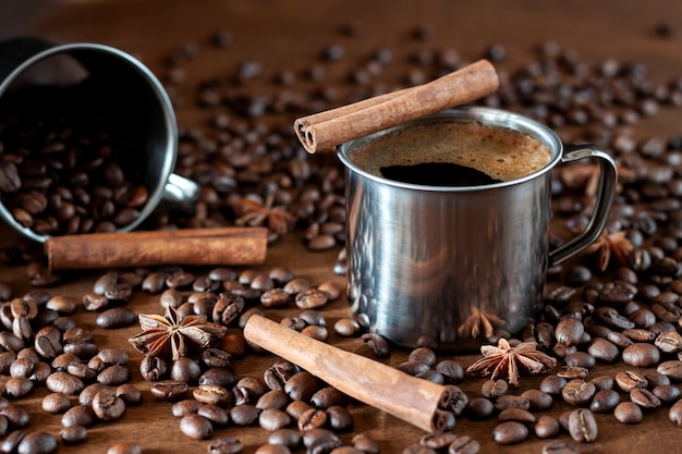 Granos de café tostados, canela en rama y anís estrellado yacen sobre una mesa de madera