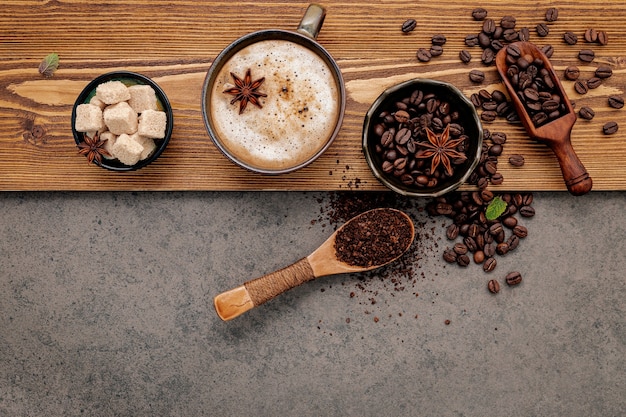 Granos de café tostados con configuración de taza de café en piedra oscura.