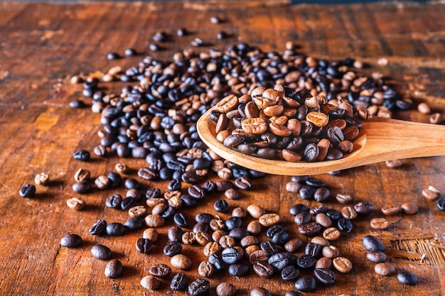 Granos de café tostados en una cuchara de madera.