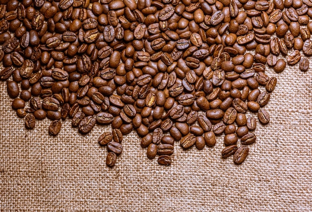 Granos de café tostados con fondo de arpillera
