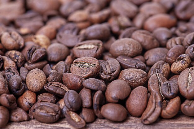 Granos de café tostados en una foto macro de fondo de madera