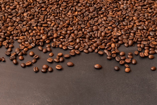 Granos de café tostados frescos sobre fondo oscuro enfoque selectivo