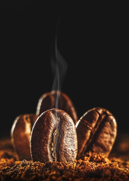 Granos de café tostados con humo aromático.